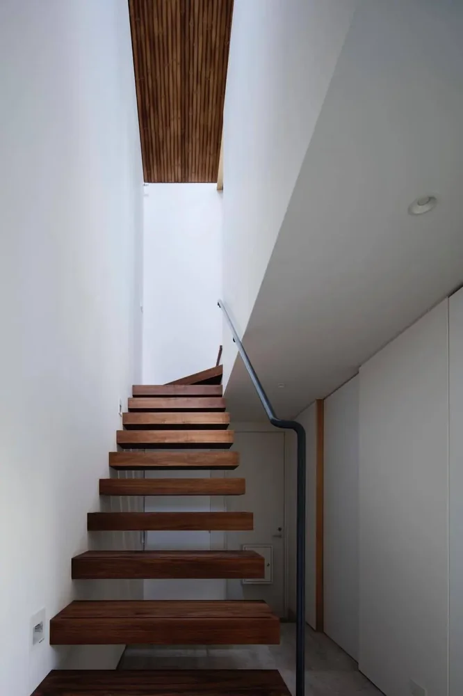 The long corridor features a folded ceiling that follows the roof’s profile, creating a continuous spatial flow.
