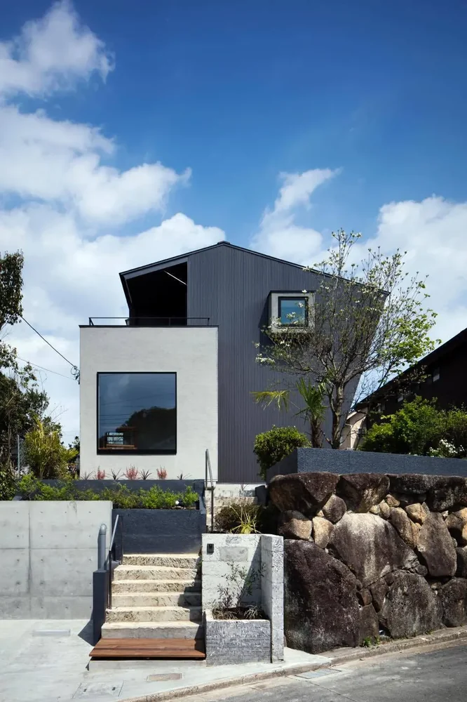 Ateliers are positioned facing the street on the first and second floors, featuring square windows of varying sizes.