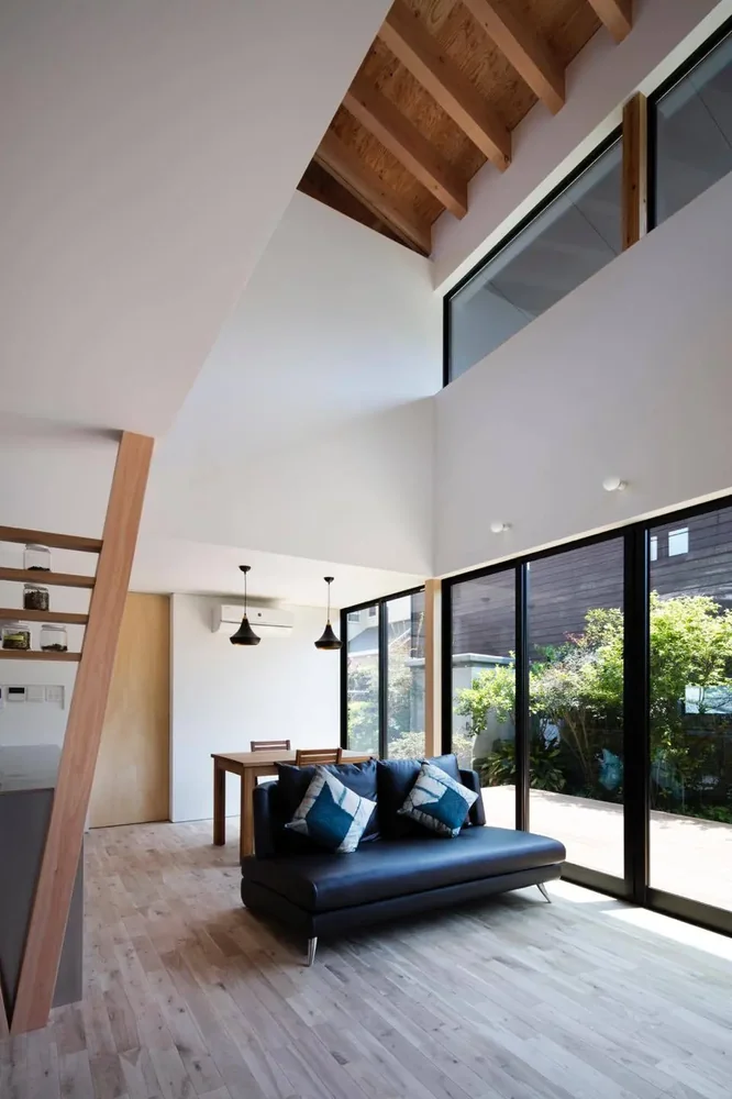 The family living spaces open onto a garden adjoining the neighboring property.