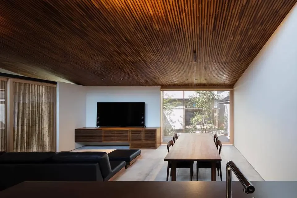 A layered spatial experience emerges through the interplay of the building, courtyards, and the parallel alleyway.