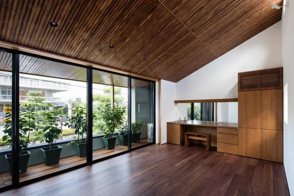 Through a hibiscus sunroom, the corridor connects to the busy vehicular road outside.
