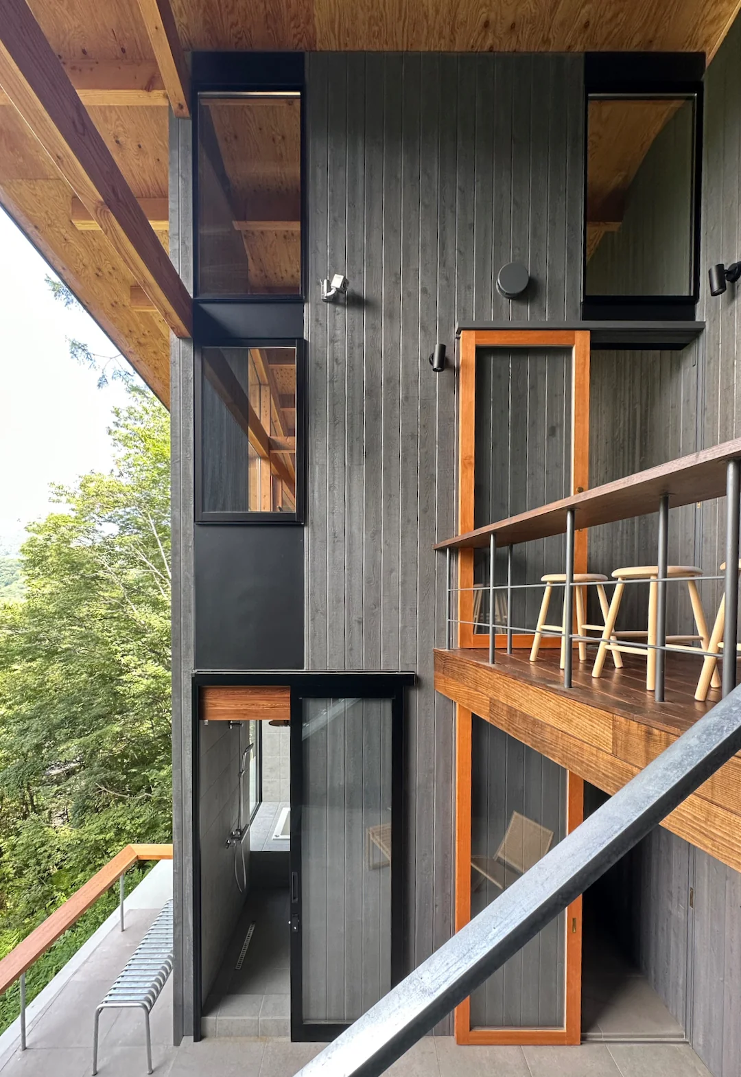 The valley-side, central living area features vertically clad exterior walls designed to blend seamlessly with the surrounding trees｜Karuizawa Terrace