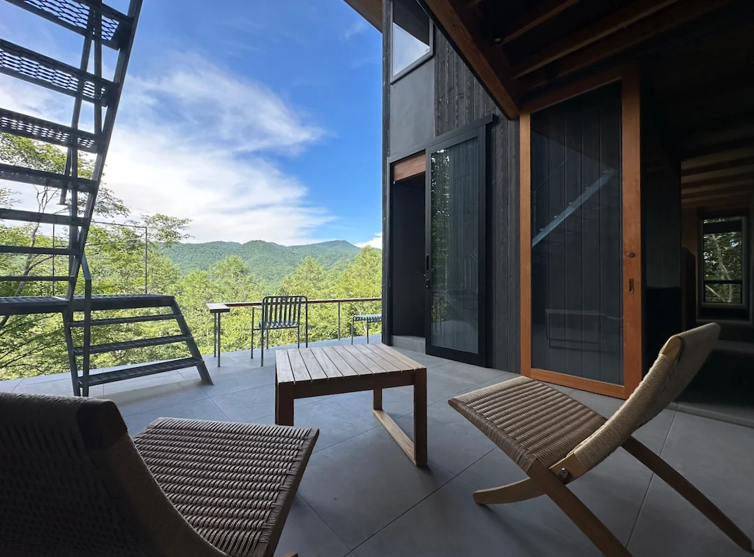 The proximity to the view on the valley side evokes suspension, while the recessed position fosters a sense of security—two sensations expressed through room depth｜Karuizawa Terrace