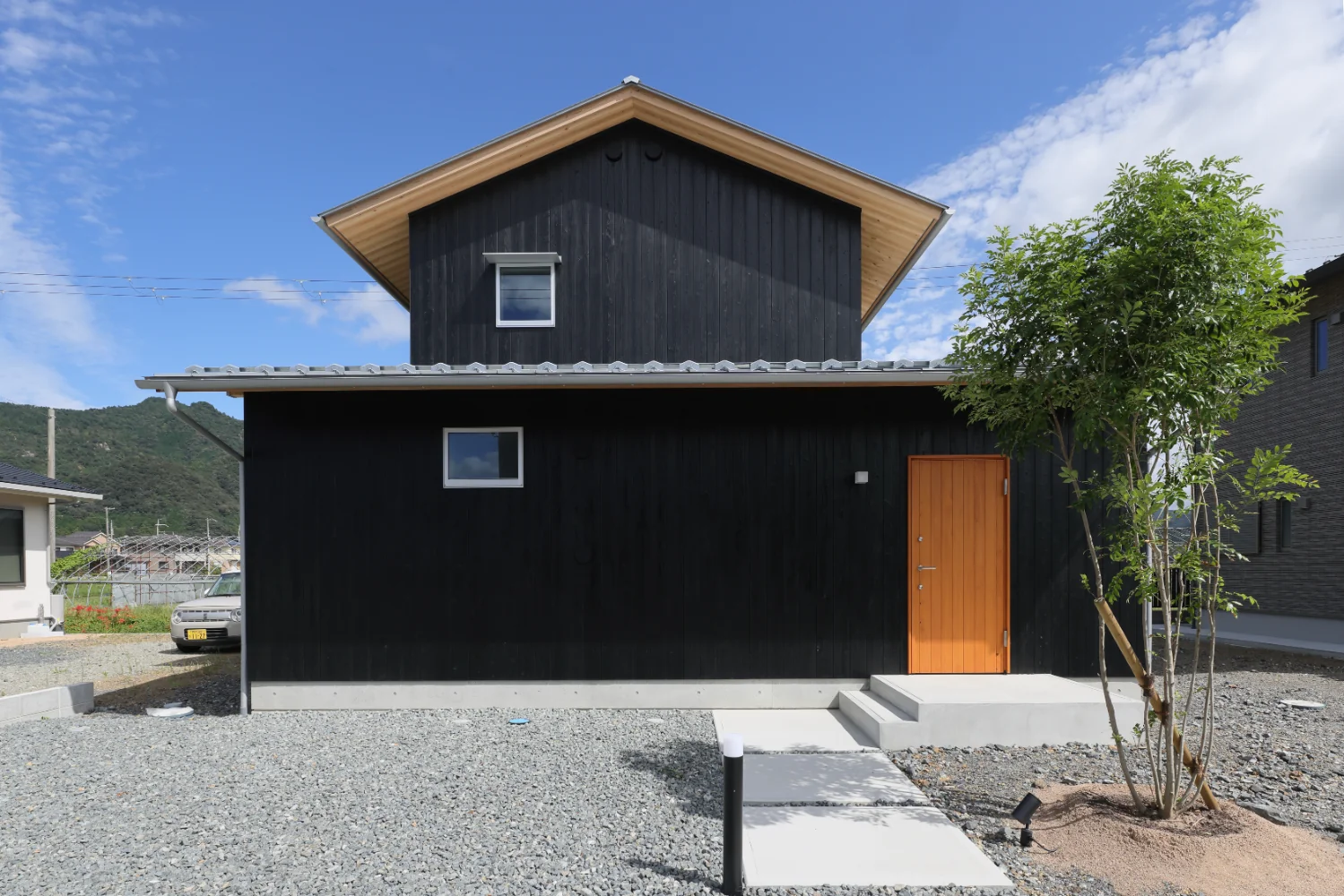 新規分譲地の中に建つ木の外壁を持つ住まいは新鮮に見えます