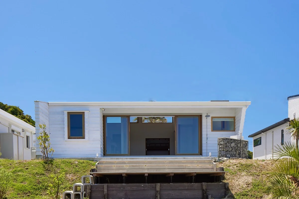 The entrance dirt floor and central patio of the building extend continuously into the terrace overlooking the sea.｜Iwai Beach House