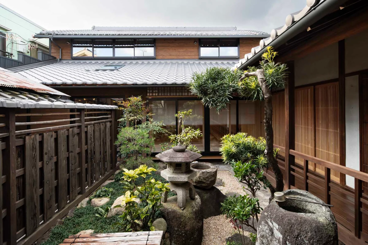 母屋より見た全景。外壁は杉板鎧貼り。傷みの激しかった下屋は瓦屋根を葺き替え。｜大きな吹き抜けのある古民家の改修｜きたまちの家