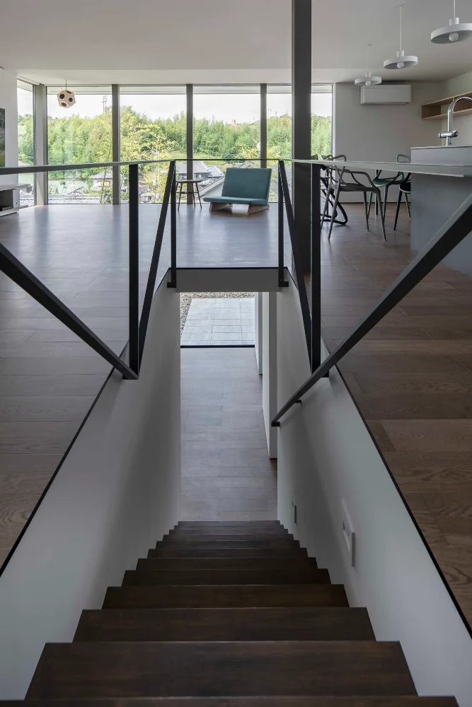 Descending the stairs leads to the family's plaza, beyond which is a deck paved with flat concrete slabs.