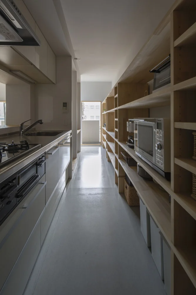 A through-passage with the kitchen and study arranged in series. A 4.9 m-long element functions as both the kitchen back set and bookshelf.