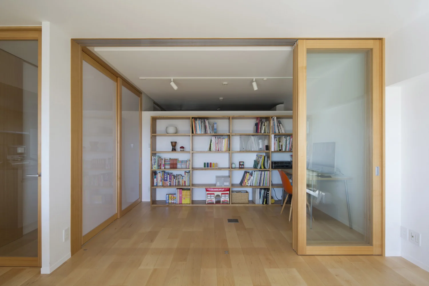 The four-panel sliding doors are suspended to accommodate their weight, with floor-embedded stoppers permitting fixation at any position.