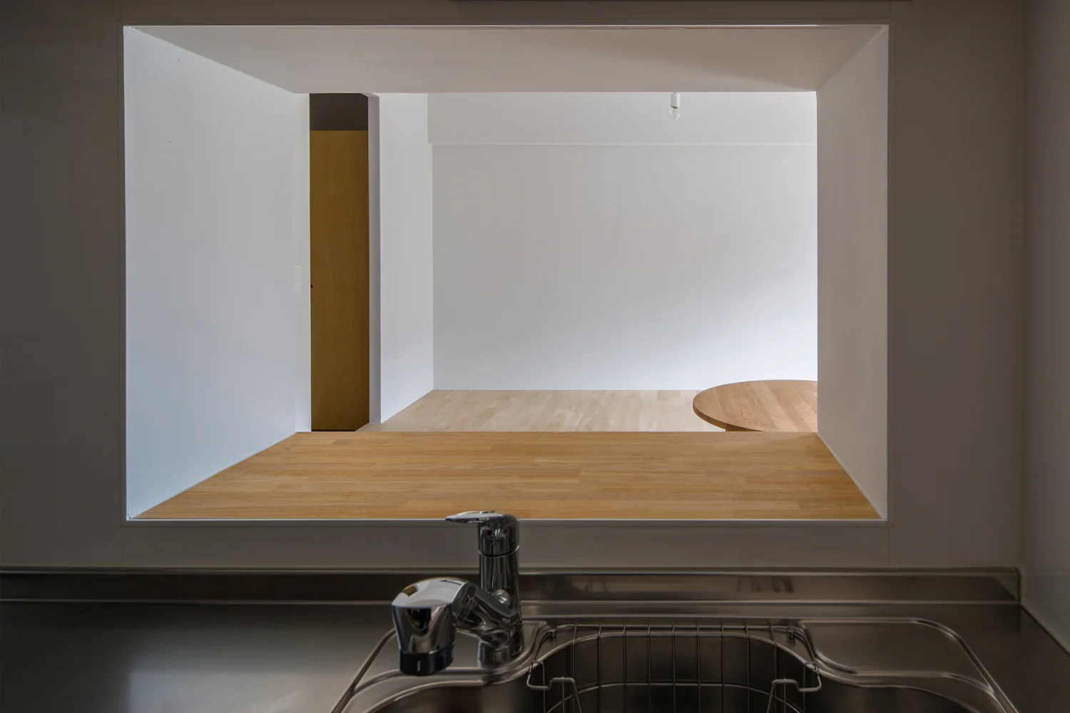 View of the raised seating area through the kitchen's small window.
