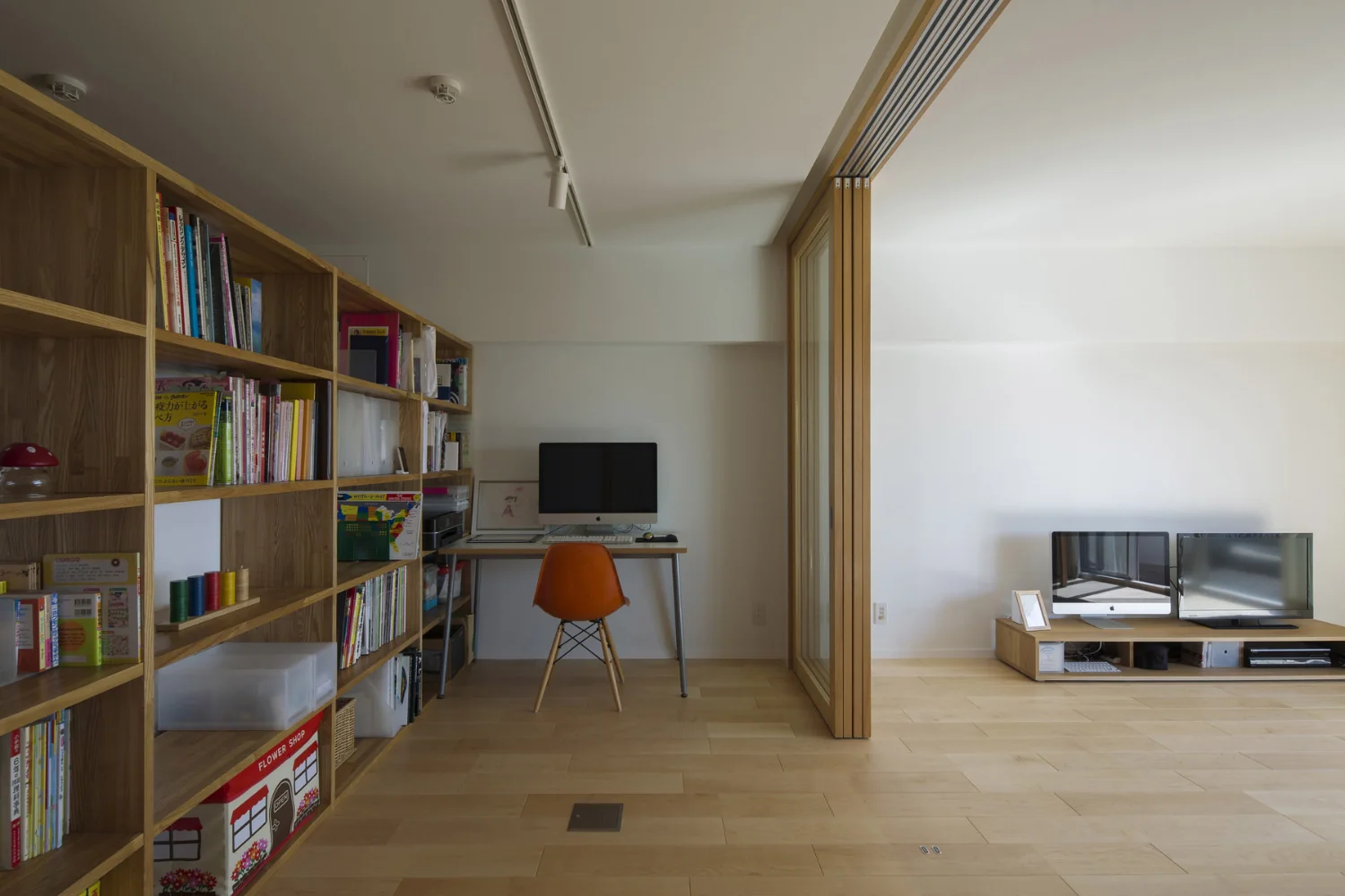 The large bespoke bookshelf (3.3 × 1.8 m) was fabricated in sections for the high-rise delivery and assembled on site.