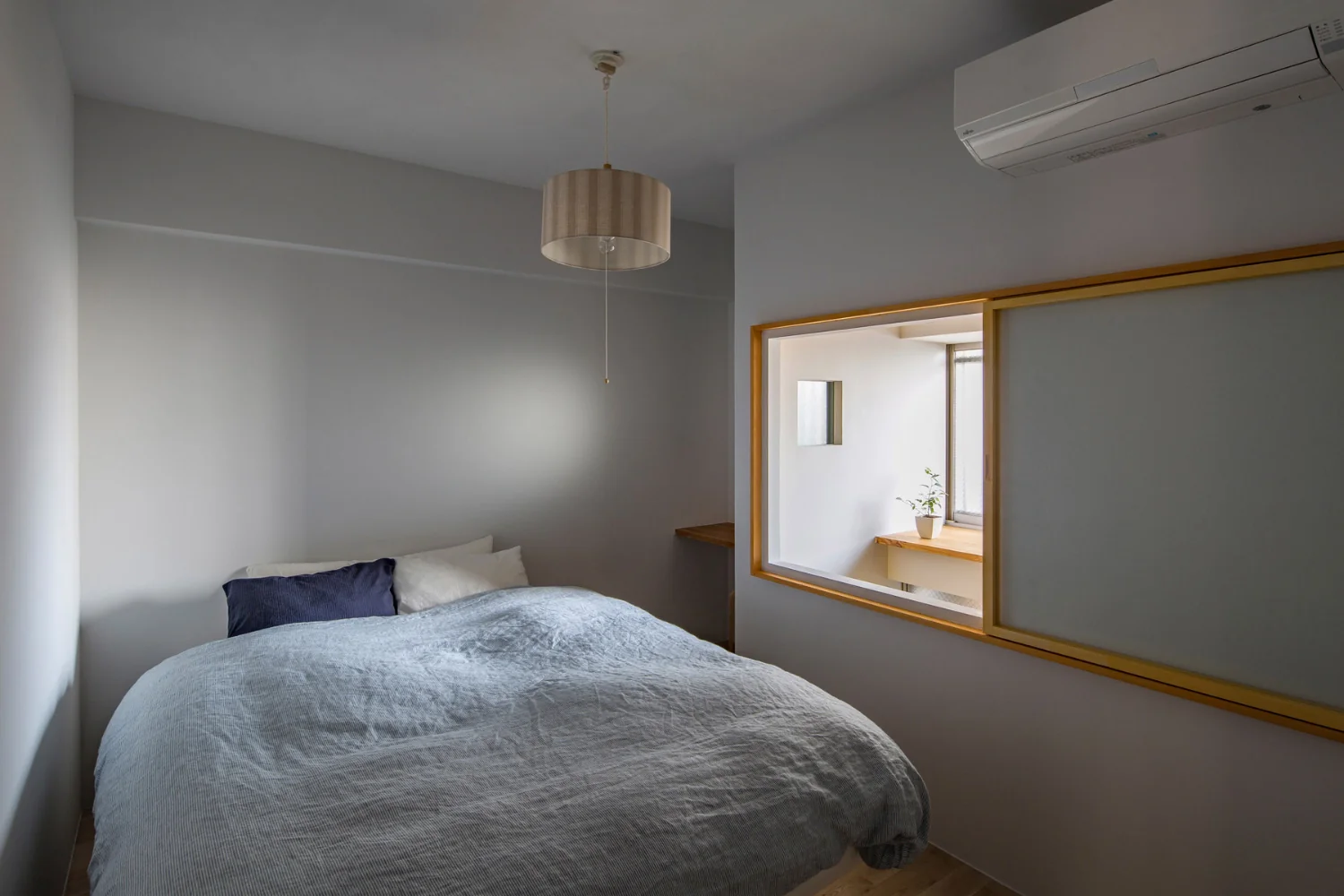 Bedroom illuminated by soft light filtering through a narrow gap.