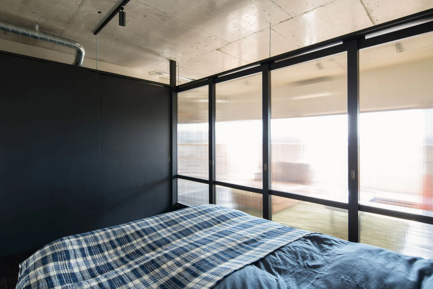 A bedroom suffused with light through polycarbonate panels.