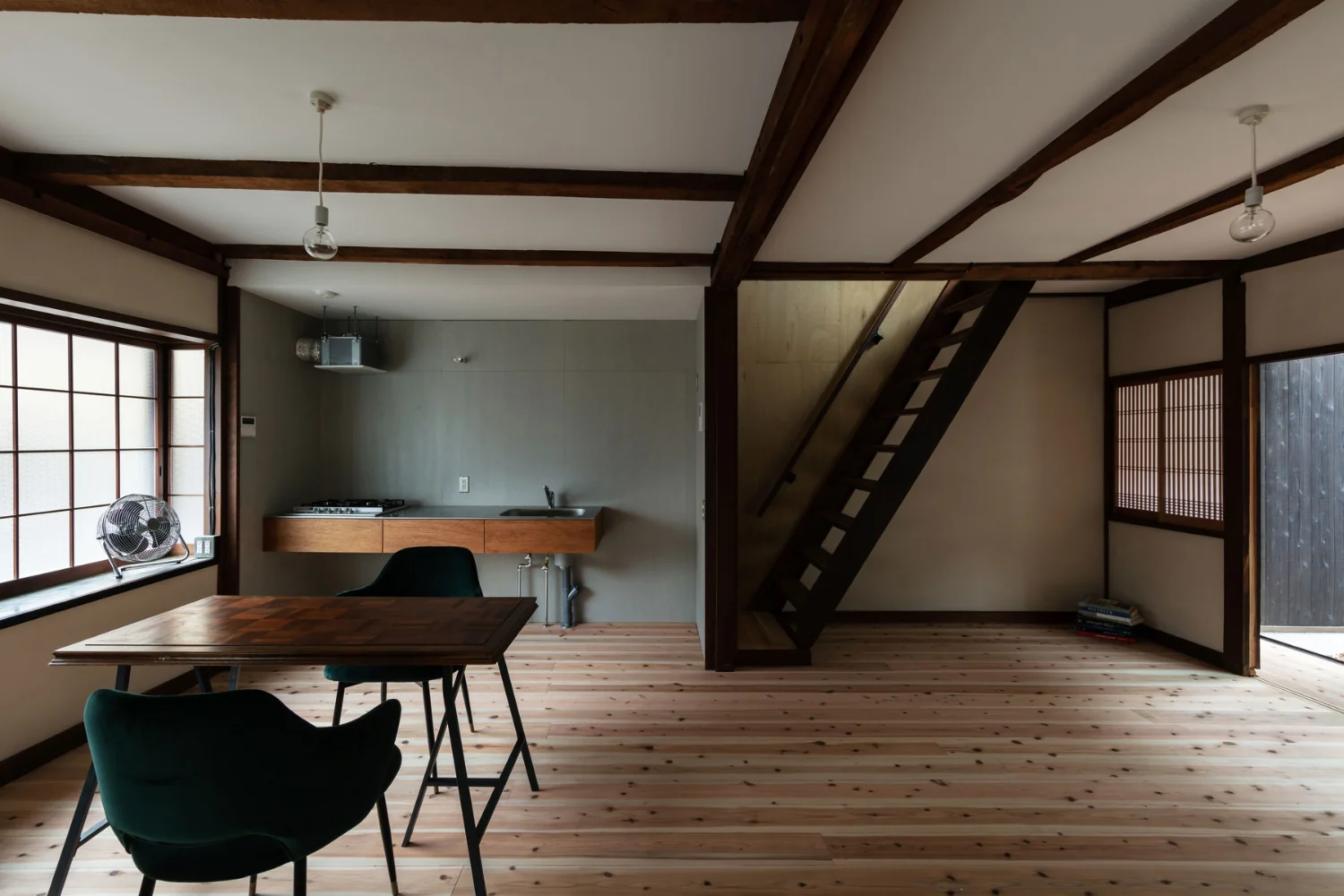 The staircase originally located inside a closet was replaced with an open‑riser (strip) stair. A shoin‑style shoji screen functions as the visual terminus.｜Renovation Bringing Light to a Rental Row House | Row House on Showa Alley II