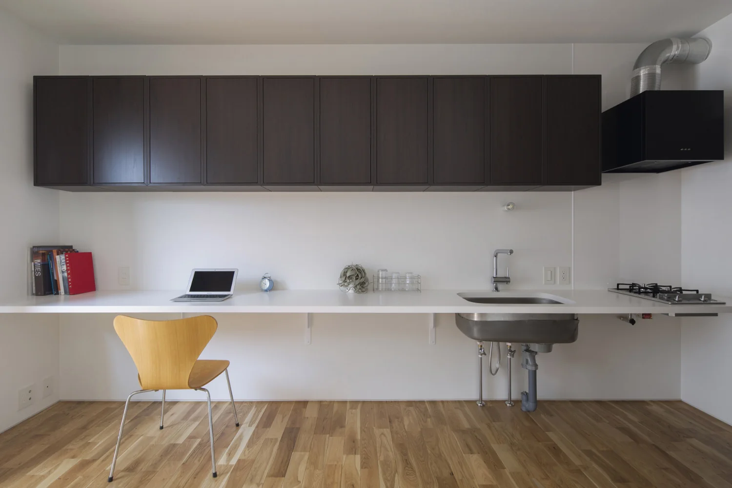 A bespoke 4.3 m–long multipurpose counter with overhead cabinets. Flooring is solid Nara oak.｜Studio Apartment with Private Garden and Large Desk | D#102