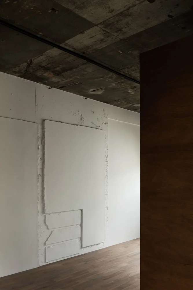 The traces imprinted on the walls are abstracted in white, creating room for interpretation.