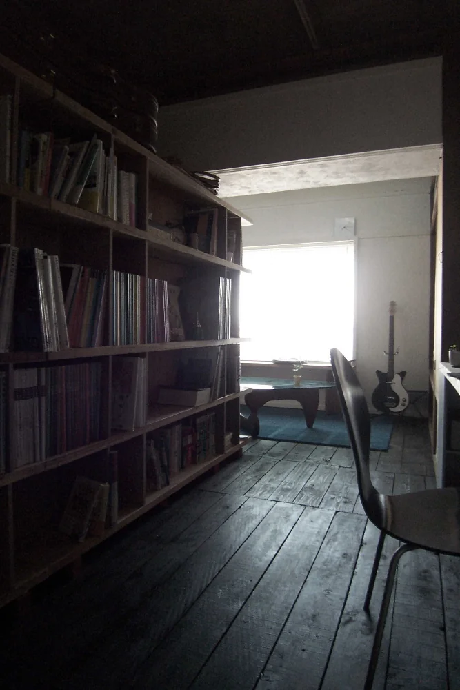 A studio space partitioned by shelving fabricated from cedar scaffold boards and lauan laminated plywood.
