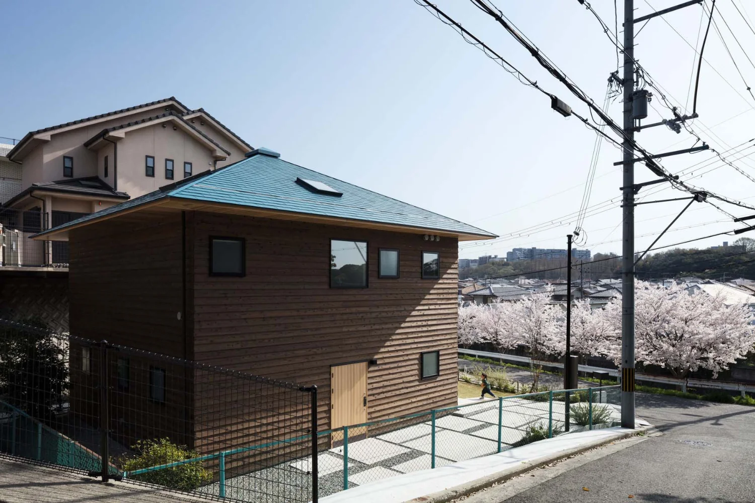 The approach is a square concrete entry court that echoes the form of the building.