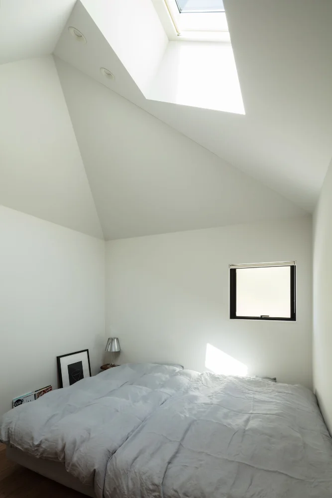 小さな家の中。トップライトから光が射す。｜四つの小屋と路地の家｜四つ角の家