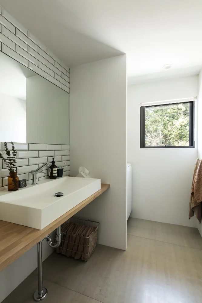 Washroom and bath that enjoy views of the woodland; walls are finished with subway tile.