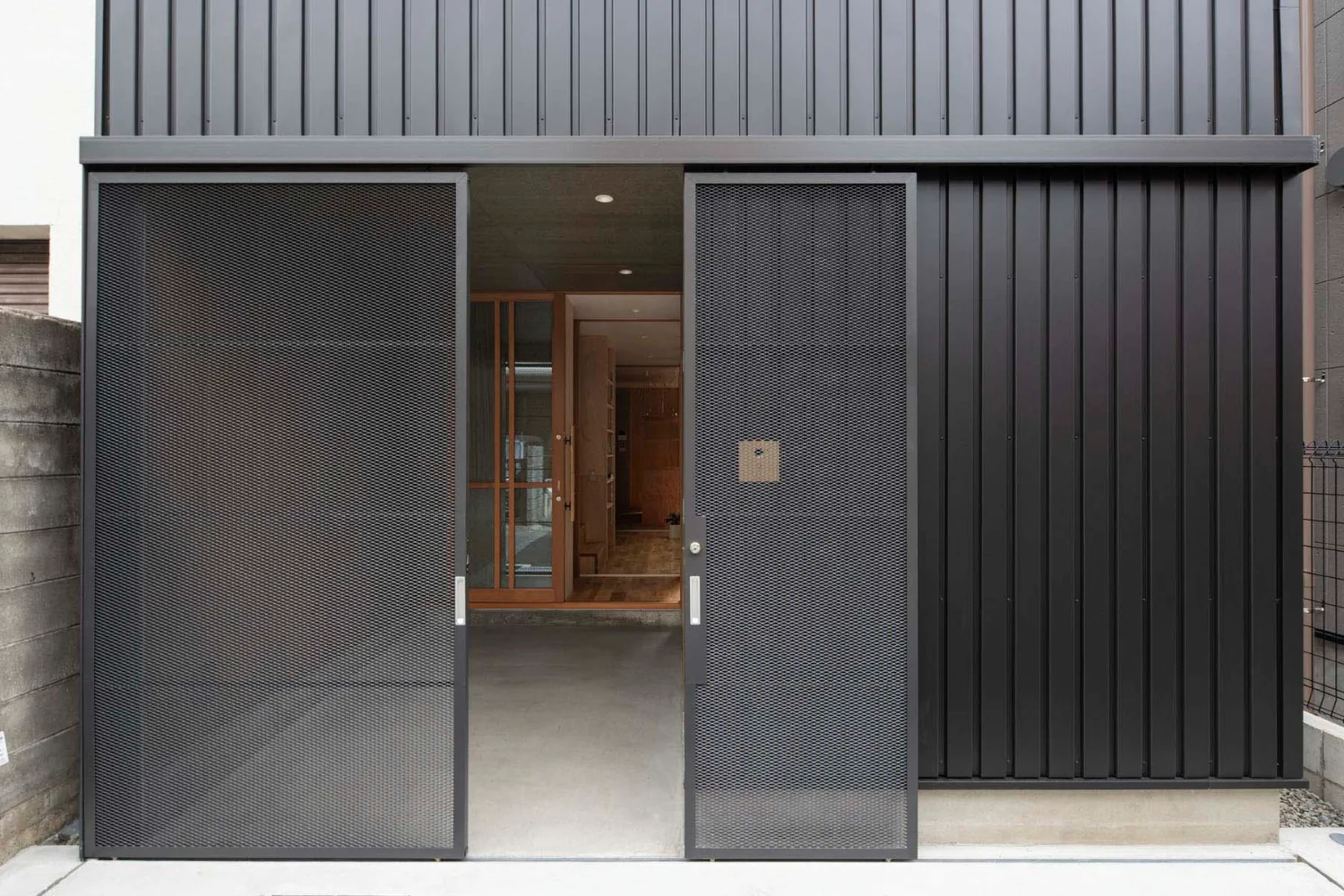 Slim expanded-metal paired suspended doors.