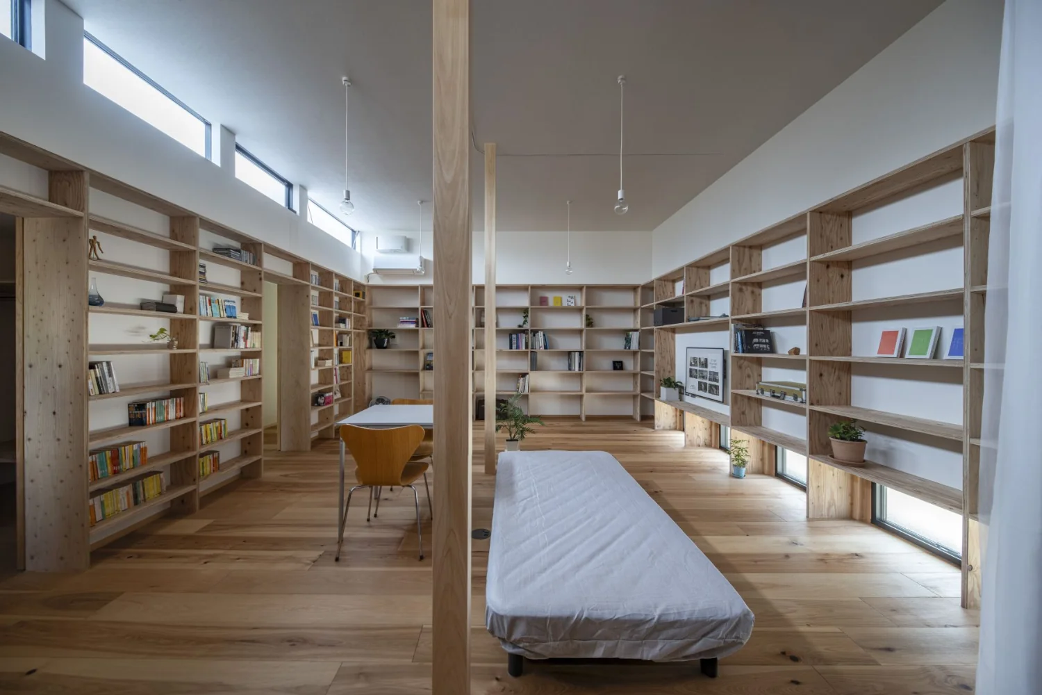 A large living space consolidating eating, sleeping, working, and leisure for a single occupant.