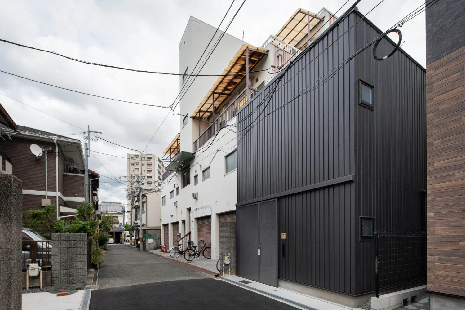 Exterior walls are clad in ribbed Galvalume steel, referencing materials and construction methods commonly found in the neighborhood.