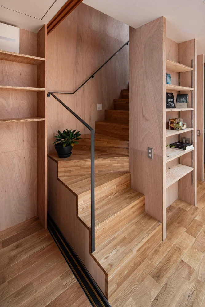 A compact winding staircase. The handrail is a slender steel flat bar.｜A Small House for Open Living in the Gap Between Buildings | Kigawa Row House