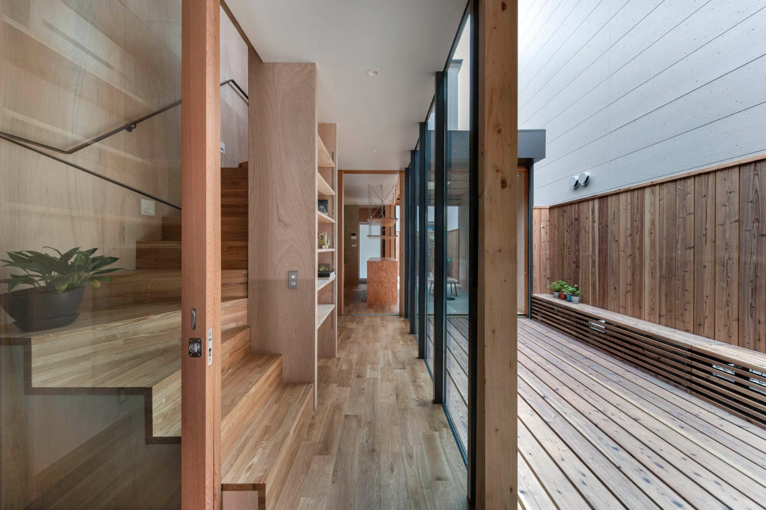 The engawa bench also serves as an enclosure for the air-conditioning outdoor unit.｜A Small House for Open Living in the Gap Between Buildings | Kigawa Row House