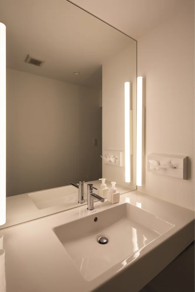 Lighting employs the so‑called 'dressing‑room' style, using linear LED tube fixtures mounted on both sides.