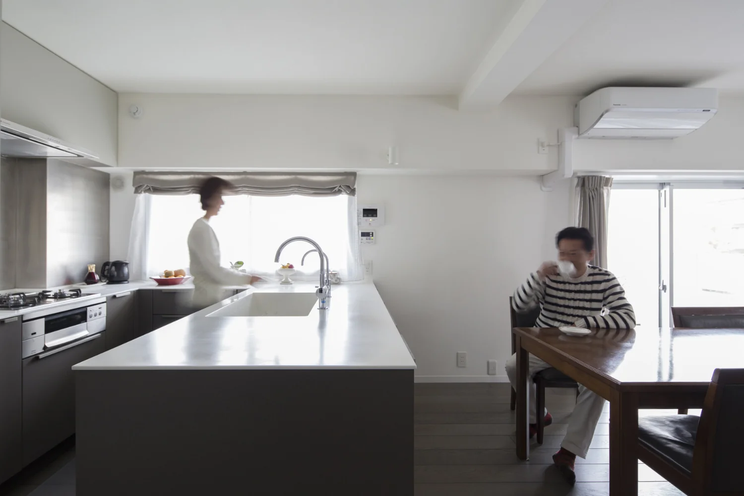 The cramped wall‑mounted kitchen was reconfigured into a U‑shaped, window‑facing layout to provide ample workspace.