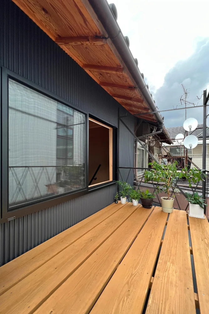 The existing iron clothes-drying rack was repainted and cedar scaffold boards were applied to form a wood deck.