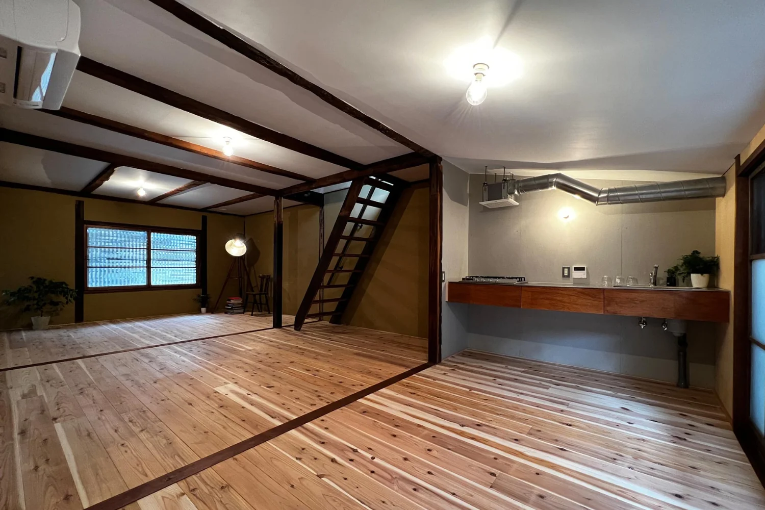 Compact kitchen. Because the existing roof is low, the exhaust fan ducting is exposed.