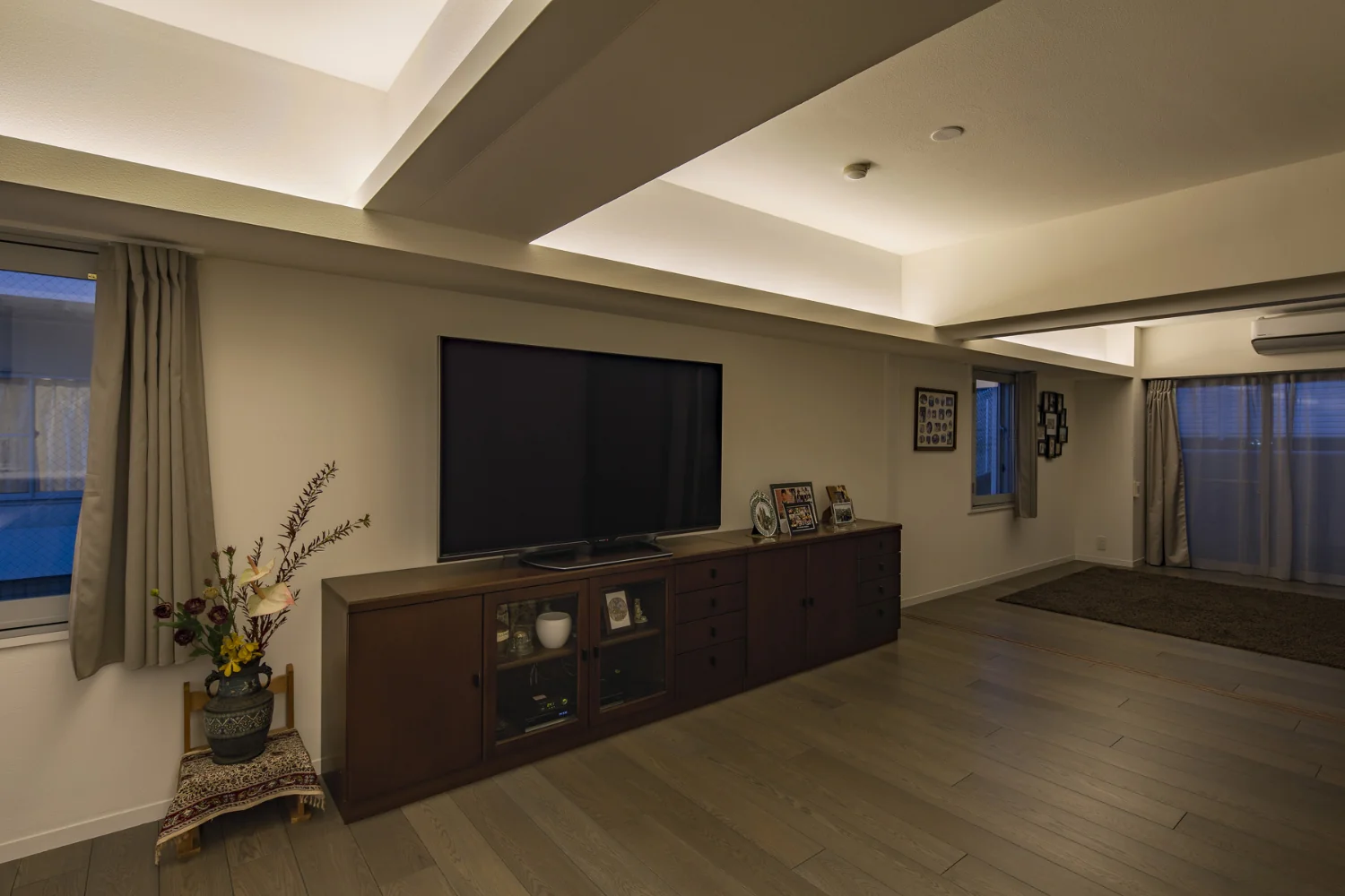 Indirect lighting is concealed within channel steel attached to the beam soffit, producing a floating ceiling effect.