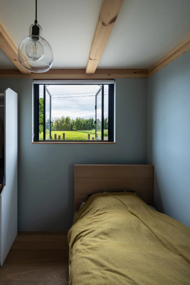 The mother’s bedroom is on the ground floor; the walls are finished in blue-gray wallpaper.｜Two-Generation Residence Under One Roof | House at the Foothills of Mount Katsuragi