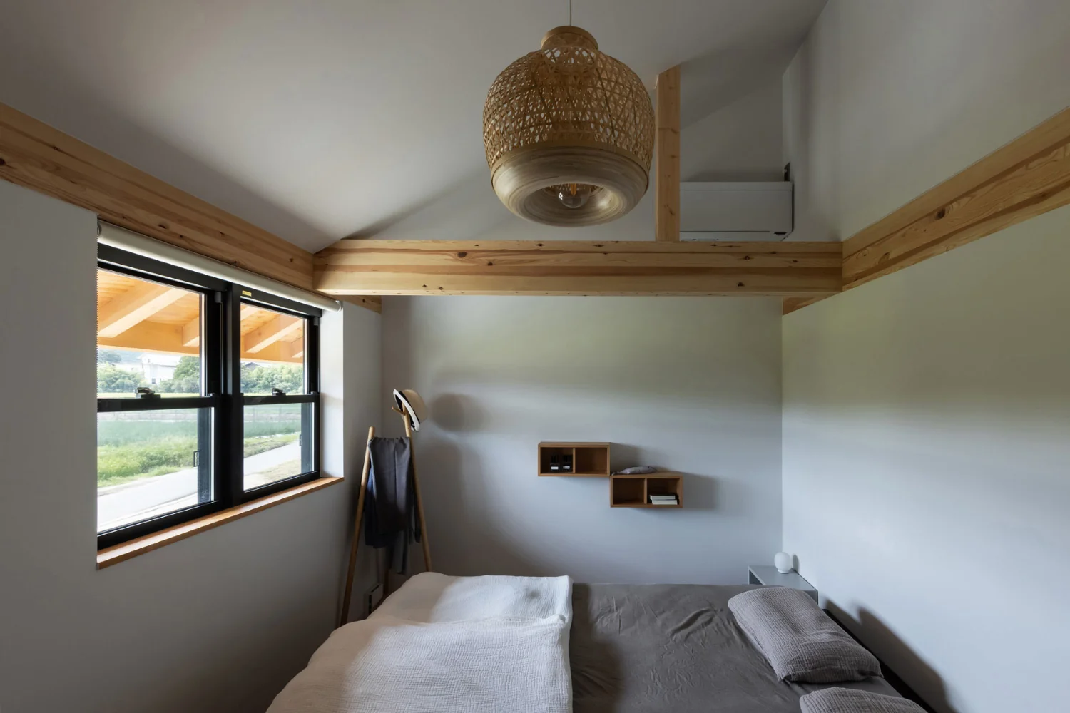 A bedroom with a high ceiling that follows the roof pitch.｜Two-Generation Residence Under One Roof | House at the Foothills of Mount Katsuragi