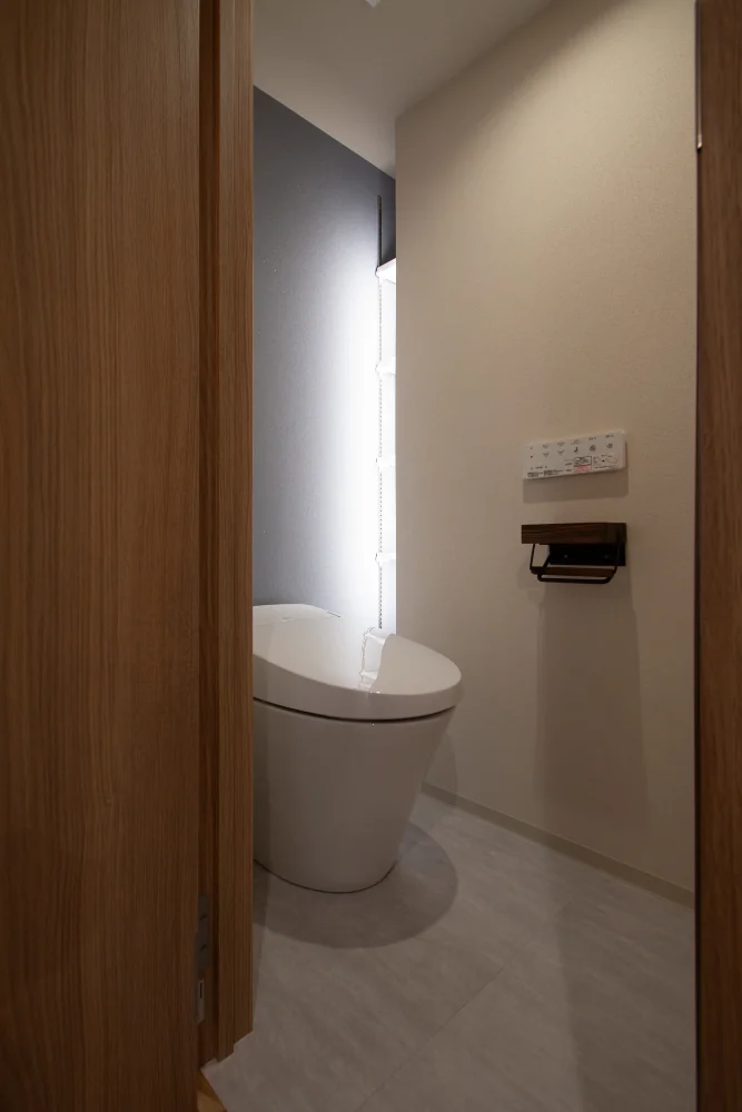 間接照明を仕込んだスリットは、トイレットペーパーを置く、隠し収納