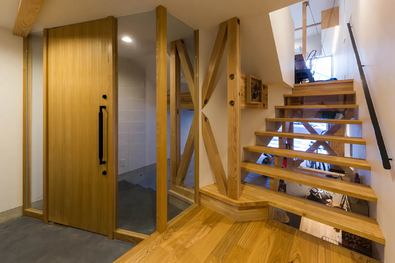 From the entrance, sightlines extend through both the lower garage and the upper living area.