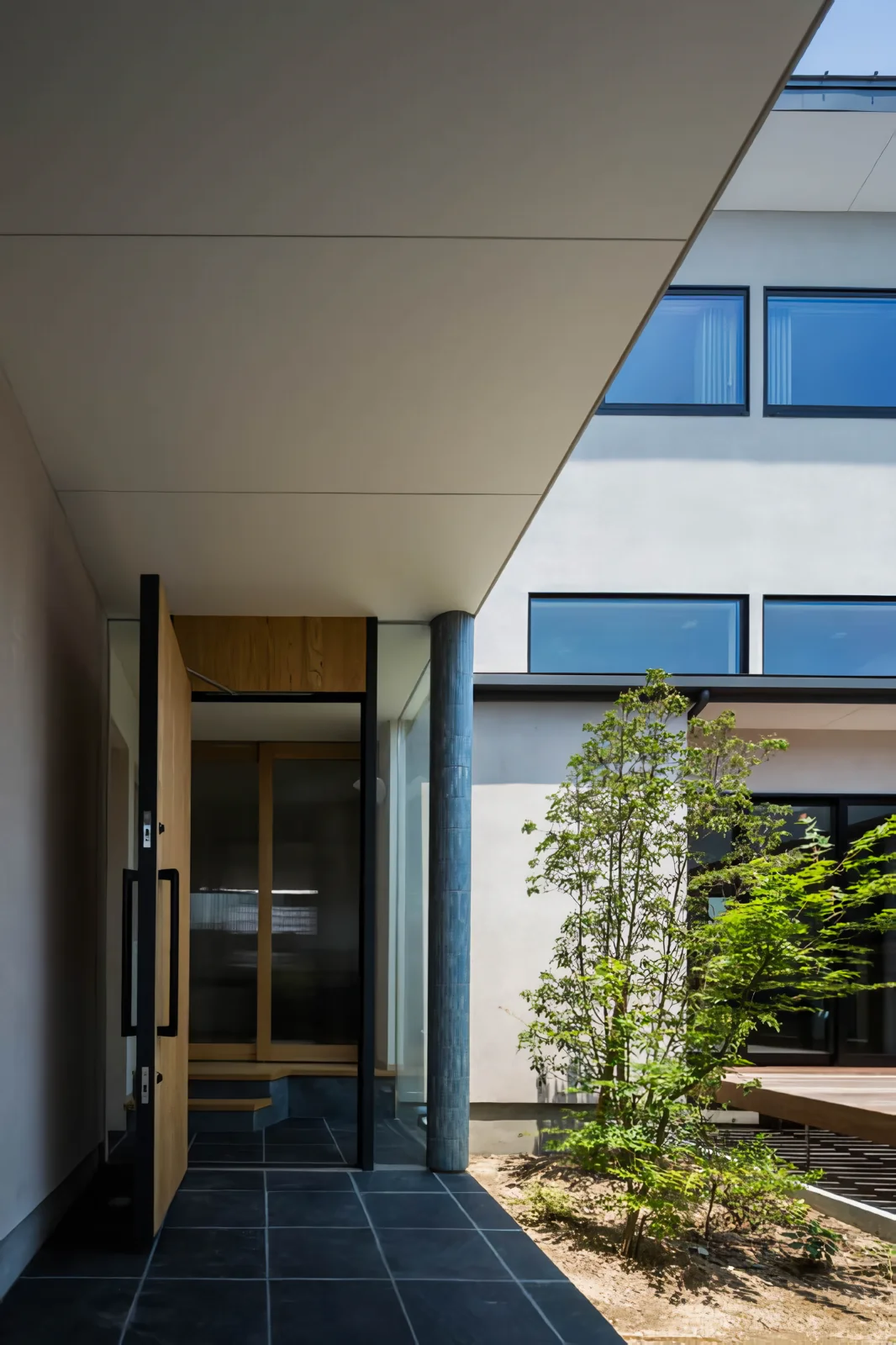 Walking along the central approach, the courtyard enclosed by the two-story and single-story sections opens up invitingly.