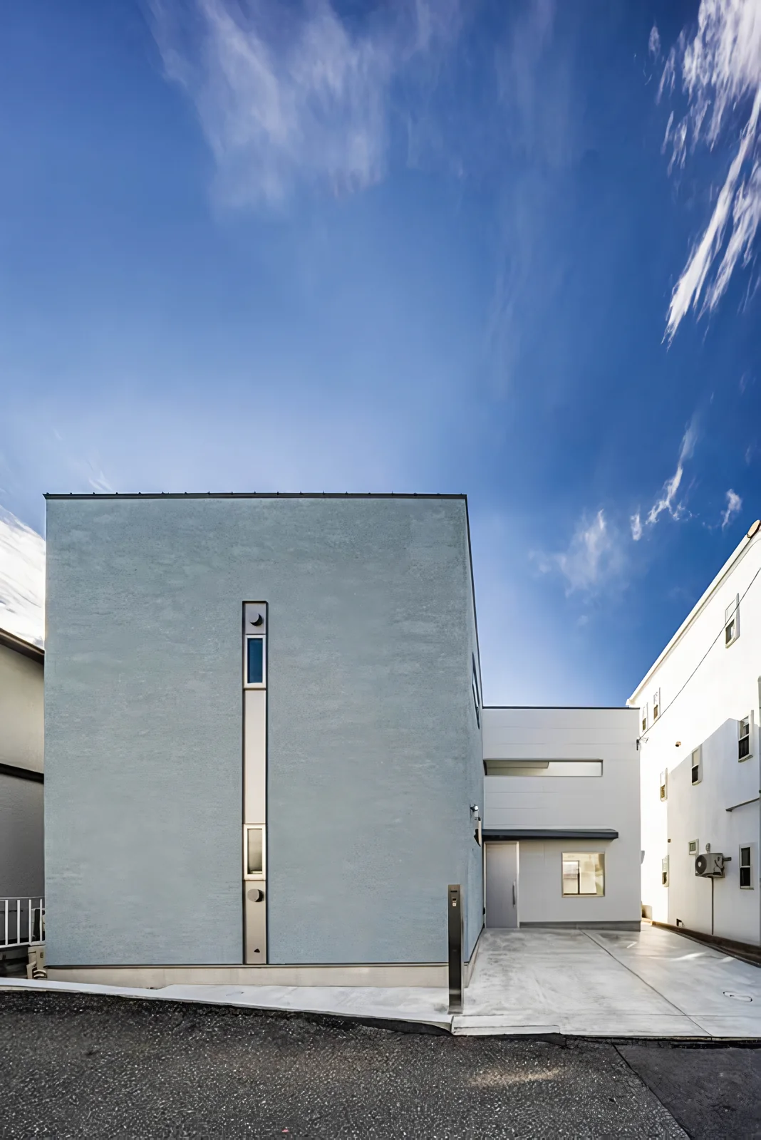 A closed box faces the street, while the office space is set back and opens to the street level.