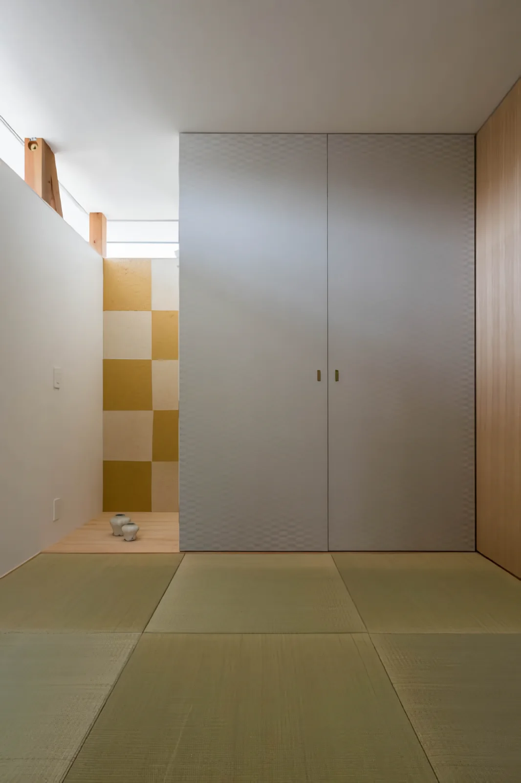 The Japanese-style room with a tokonoma alcove is illuminated by high-side windows on the road-facing exterior wall.