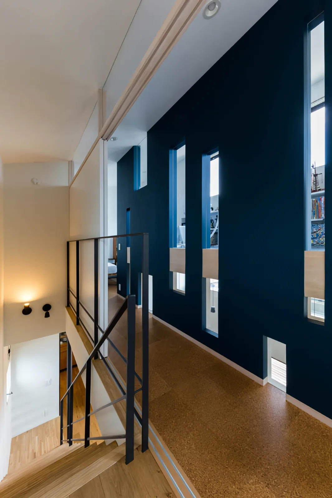 Small lower windows in the corridor wall look into the LDK, while the upper small windows reveal the raised floor of the children’s space.